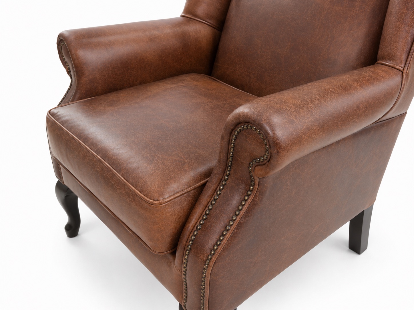 Brown leather wingback armchair armrest detail